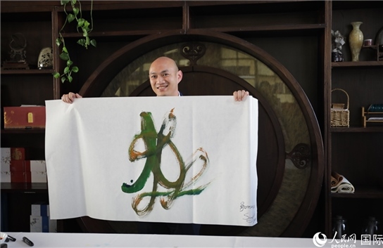 老撾駐華大使館三秘明君參加《五百筆·瀾湄合作》集體藝術(shù)創(chuàng)作。人民網(wǎng)王婧攝。