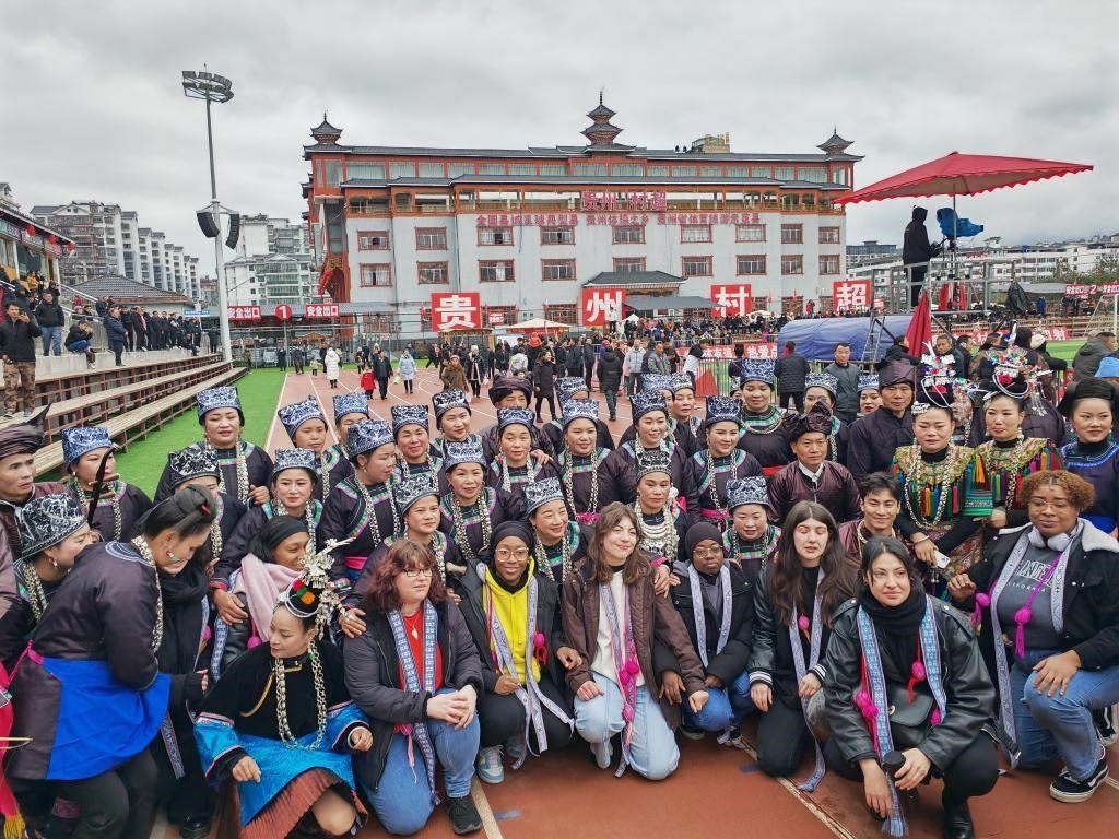 法國(guó)青年在“村超”賽場(chǎng)邊與參加表演的村民合影。新華社記者 羅羽 攝