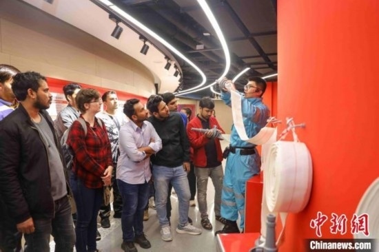 5月9日，工作人員指導(dǎo)留學(xué)生正確使用消防水帶。張鷹 攝