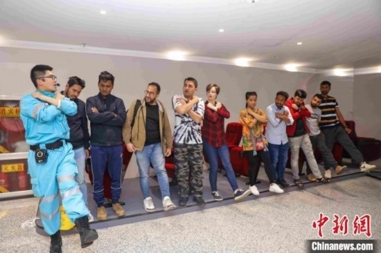 5月9日，工作人員指導(dǎo)留學(xué)生練習(xí)逃生技巧。張鷹 攝