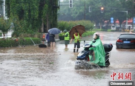 5月10日，廣西沿海遭遇強(qiáng)降雨。圖為欽州市民眾在積澇中出行。陸敏 攝