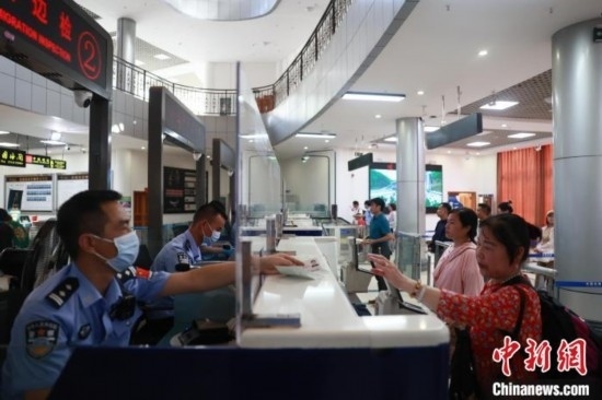 圖為旅客在磨憨口岸辦理通關(guān)手續(xù)。雷雨 攝