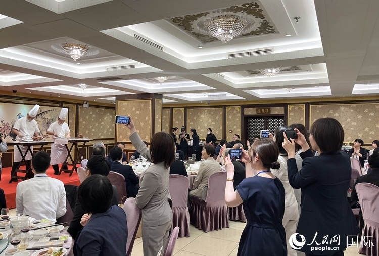 國(guó)家級(jí)非物質(zhì)文化遺產(chǎn)、全聚德片鴨工藝吸引代表團(tuán)成員拍照留念。