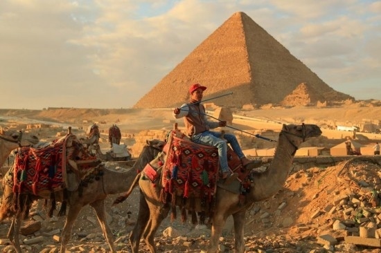 1月24日，商販騎駱駝離開埃及吉薩金字塔景區(qū)。新華社記者 隋先凱 攝