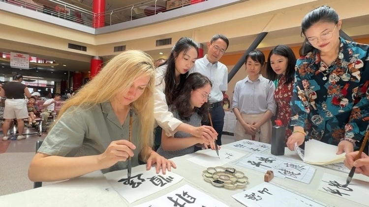 羅馬尼亞友人在活動現(xiàn)場學(xué)寫漢字。中國駐羅馬尼亞大使館領(lǐng)僑處供圖