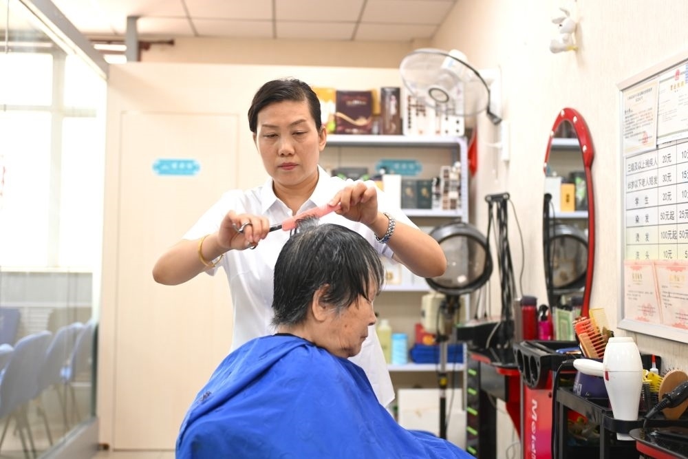 6月20日，長(zhǎng)城花園社區(qū)的志愿者為居民理發(fā)。