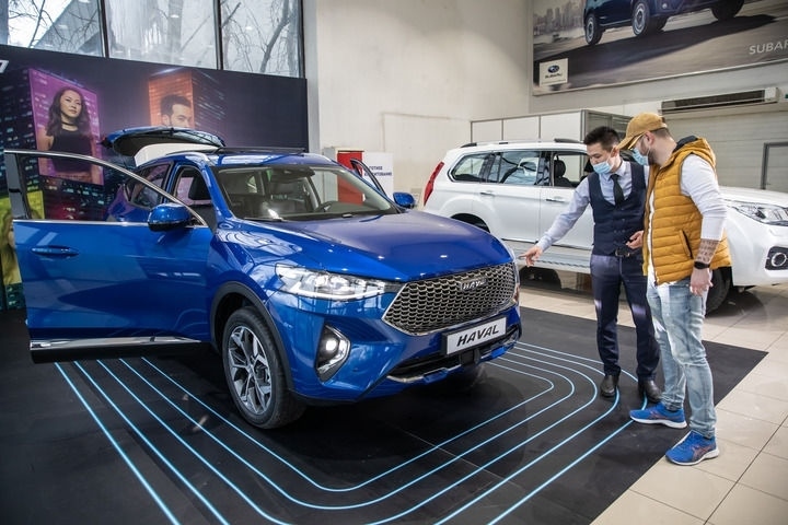 2021年4月1日，銷售人員在哈薩克斯坦阿拉木圖市經(jīng)銷商店向消費(fèi)者介紹哈弗汽車。新華社發(fā)（阿斯塔納汽車公司供圖）