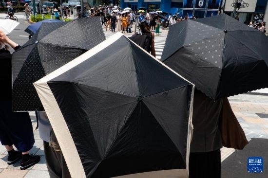 7月4日，人們?cè)谌毡緰|京原宿的街道上等待紅綠燈。新華社記者 張笑宇 攝