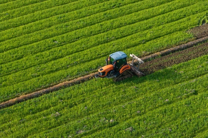 2024年3月19日，在湖南省常德市鼎城區(qū)謝家鋪鎮(zhèn)港中坪村，村民駕駛農(nóng)機(jī)翻耕田地（無(wú)人機(jī)照片）。新華社記者 陳思汗 攝