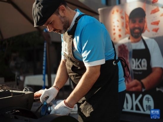 7月19日，在蕪湖古城，馬丁在當(dāng)天舉行的啤酒節(jié)上制作牛排。新華社發(fā)（繆雨晨 攝）