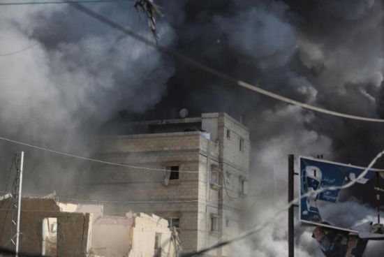 7月21日，在加沙地帶中部的努賽賴特難民營，遭以軍空襲的建筑冒出滾滾濃煙。新華社發(fā)（馬爾萬·達(dá)烏德攝）