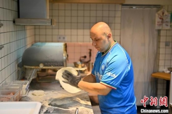 近日，韋榮耀在自家披薩小店內(nèi)忙活。俞靖 攝