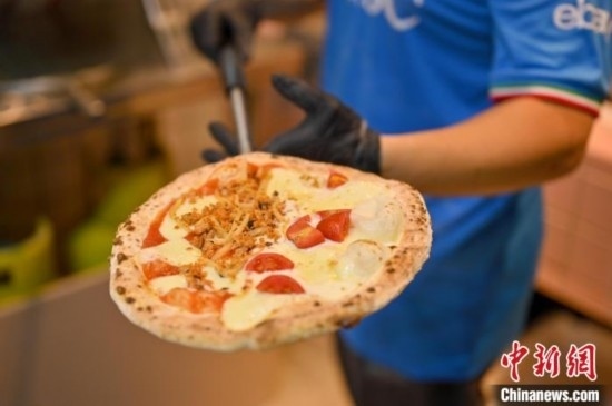 近日，韋榮耀展示他制作的“老友味”披薩。 俞靖 攝