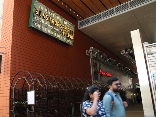 2023年5月29日，人們經(jīng)過(guò)美國(guó)紐約曼哈頓的“國(guó)債鐘”。“國(guó)債鐘”是一個(gè)大型計(jì)數(shù)器，它實(shí)時(shí)更新美國(guó)的公共債務(wù)總額，并顯示出每個(gè)美國(guó)家庭所要負(fù)擔(dān)的數(shù)額。 新華社記者劉亞南攝