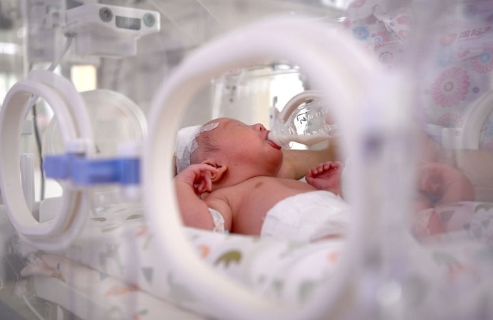 2024年6月1日，在西安國(guó)際醫(yī)學(xué)中心醫(yī)院新生兒科病房，護(hù)士為新生兒喂奶。 新華社記者 劉瀟 攝