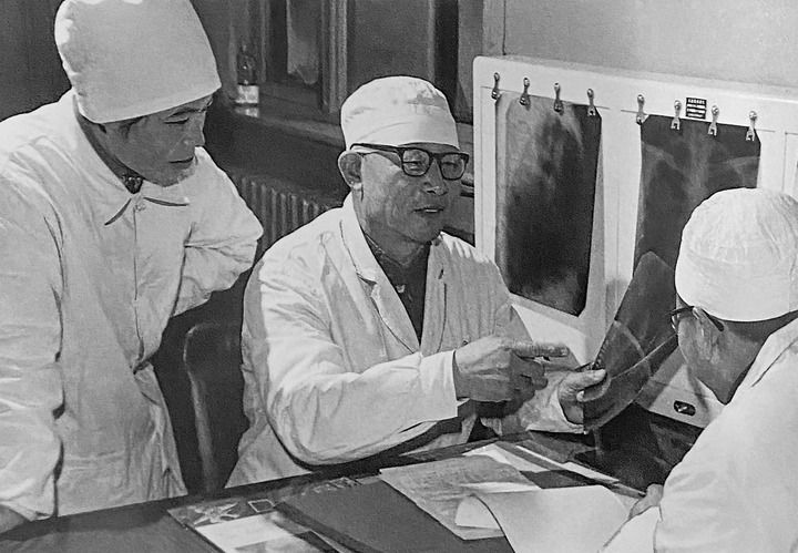 1980年1月16日，中日友好醫(yī)院首任院長(zhǎng)辛育齡（中）在內(nèi)蒙古結(jié)核病院與胸外科醫(yī)師討論病例（翻拍照片）。 新華社發(fā)
