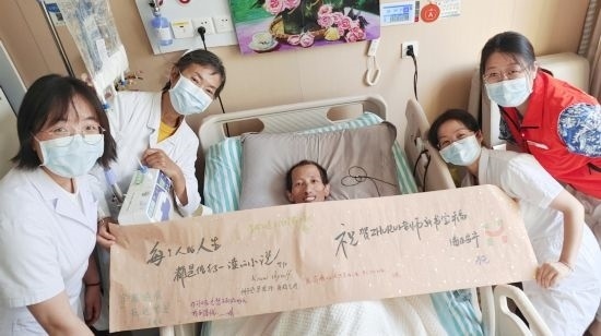 7月26日，海淀醫(yī)院安寧療護(hù)科醫(yī)護(hù)團(tuán)隊(duì)為朱銳送來一條寫滿祝福的橫幅。（受訪者供圖）