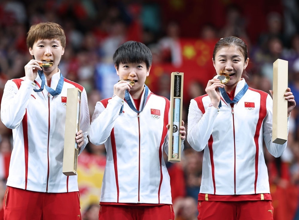冠軍中國隊選手王曼昱、孫穎莎、陳夢（從左至右）在巴黎奧運會乒乓球女子團體頒獎儀式上（2024年8月10日攝）。新華社記者 王東震 攝