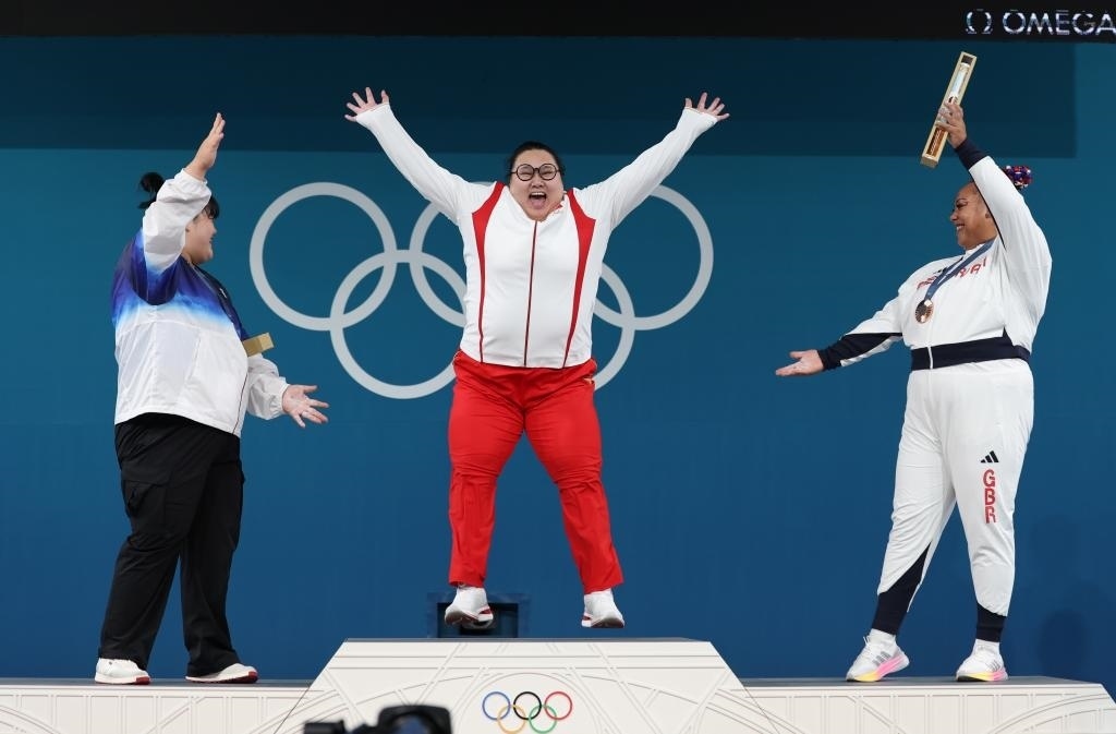 中國選手李雯雯（中）在巴黎奧運會舉重女子81公斤以上級頒獎儀式中登上領(lǐng)獎臺（2024年8月11日攝）。新華社記者 楊磊 攝