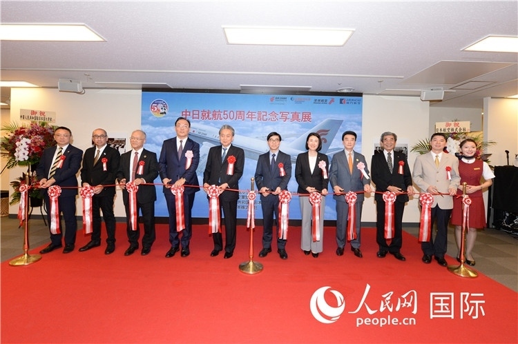 與會嘉賓共同為中日通航50周年紀(jì)念圖片展開幕剪彩。馮學(xué)敏攝