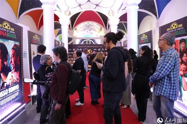 為期4天的第三屆中國(guó)－巴西電影展期間，來(lái)自中巴兩國(guó)的14部參展影片受到巴西電影愛(ài)好者和社會(huì)各界人士好評(píng)，圖為當(dāng)?shù)赜^眾在影展舉辦地巴西里約熱內(nèi)盧勞拉—阿爾維姆文化之家的迎賓廳欣賞參展電影海報(bào)。 人民網(wǎng)記者 陳一鳴攝