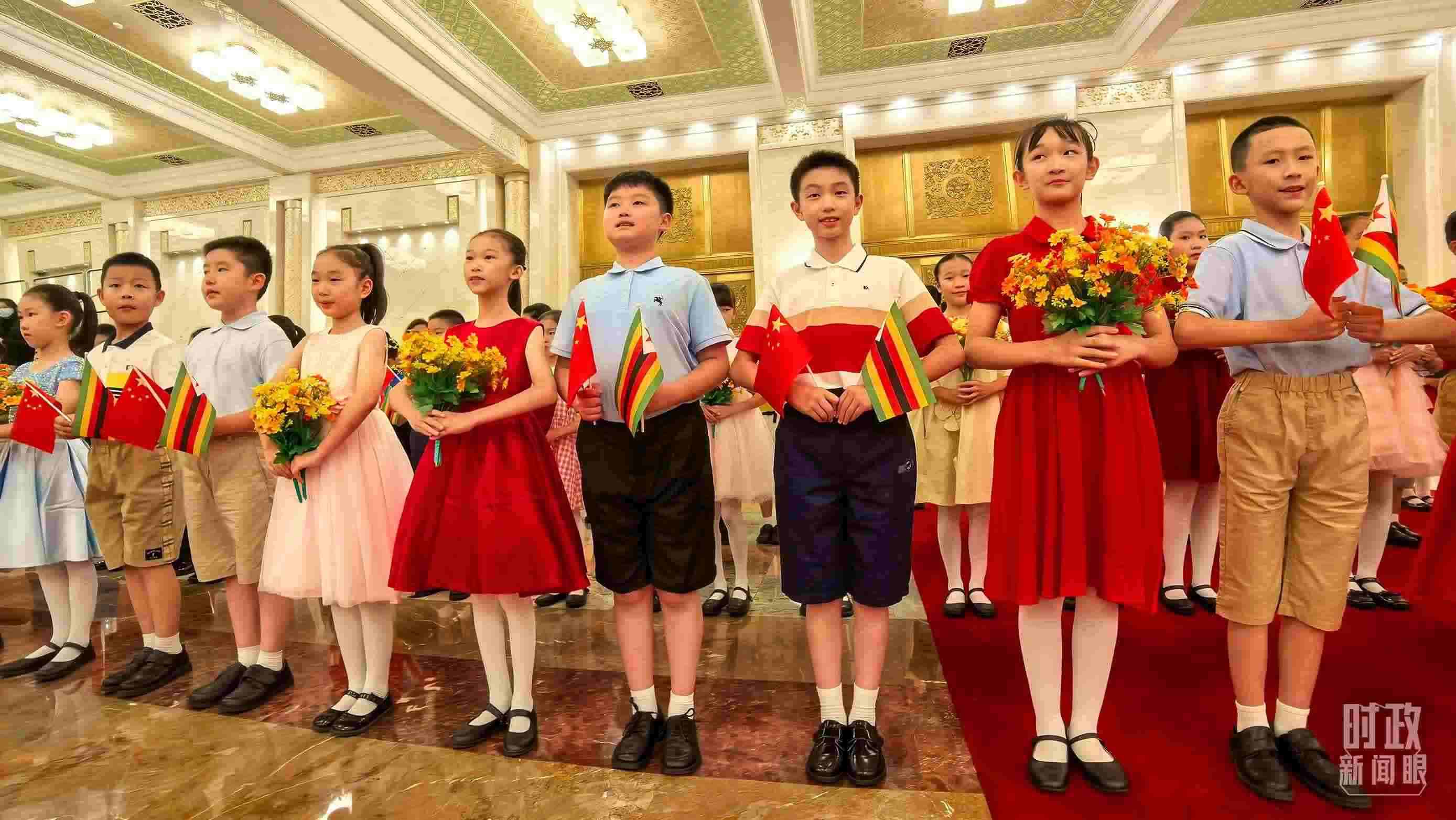 △現(xiàn)場歡迎津巴布韋總統(tǒng)訪華的青少年。（總臺央視記者鐘銳拍攝）