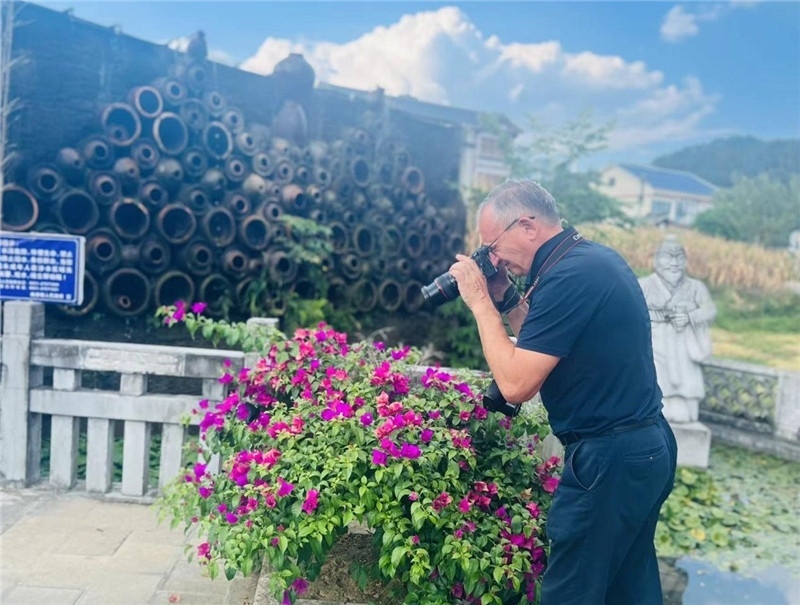 遠(yuǎn)處黔北民居錯(cuò)落有致，近處一只黑色的蝴蝶穿梭于粉紫色三角梅花叢間隙，與俄羅斯“大歐亞”總編輯弗拉基米爾·別列日內(nèi)赫的鏡頭玩起了捉迷藏，“你追我逃，不亦樂(lè)乎”。（張亞欣攝）