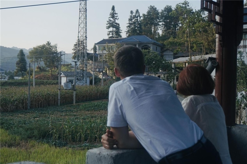 望得見(jiàn)山，看得見(jiàn)水，記得住鄉(xiāng)愁。每個(gè)人心中都有一個(gè)屬于自己的“花茂村”，在這方心田，走遍千山萬(wàn)水，鄉(xiāng)音未改鬢毛衰。吉爾吉斯斯坦《比什凱克晚報(bào)》第一副總編輯妮娜·尼奇博洛娃與《中國(guó)與俄羅斯》雜志社社長(zhǎng)奧列格·別列日內(nèi)赫攝在花茂村民居屋檐下并肩佇立，眺望山水，尋覓鄉(xiāng)愁。（李光裕攝）