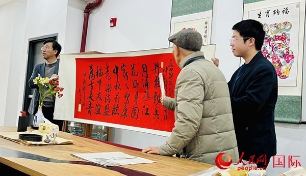 旅秘書法家向現(xiàn)場觀眾展示書法作品。人民網(wǎng)記者 宋亦然攝