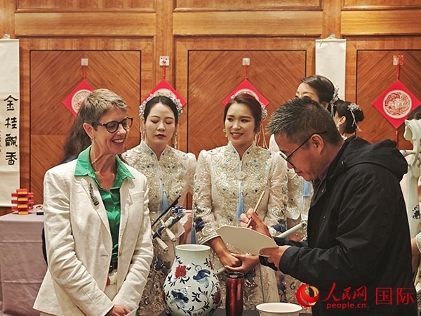 現(xiàn)場的非遺傳承人為英國觀眾展示畫技。人民網(wǎng)記者 邢雪攝