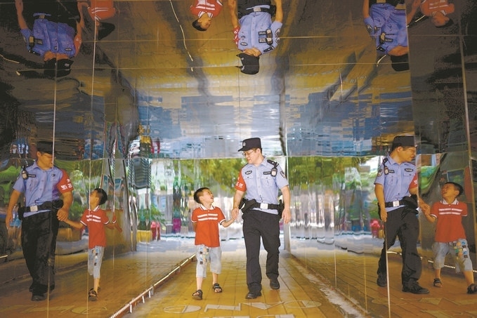 ?7月16日，重慶市公安局江北區(qū)分局一名民警在巡邏途中遇到一個獨自玩耍的小男孩，民警將其送回家。王洪平攝