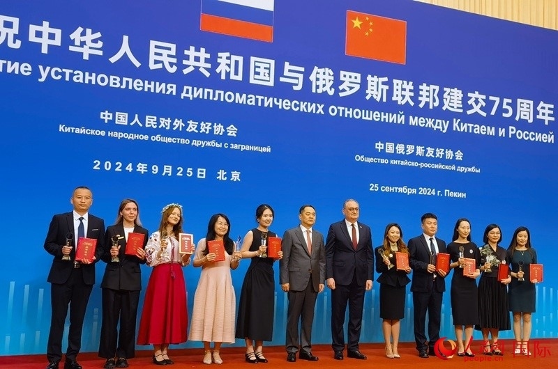 楊萬(wàn)明會(huì)長(zhǎng)和莫爾古洛夫大使為10位中俄青年友好微視頻創(chuàng)意大賽獲獎(jiǎng)代表頒獎(jiǎng)。人民網(wǎng)記者 李明琪攝