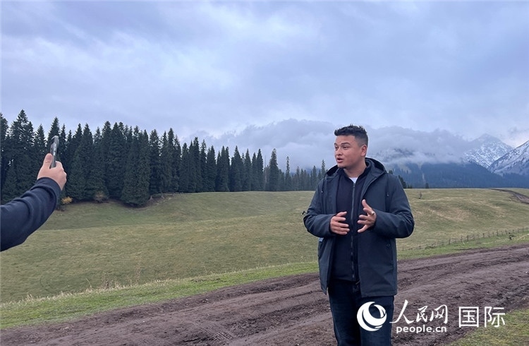 在庫爾德寧，吾買爾江被雪山美景震撼，即興錄制了短視頻作品。人民網(wǎng)記者曾書柔攝