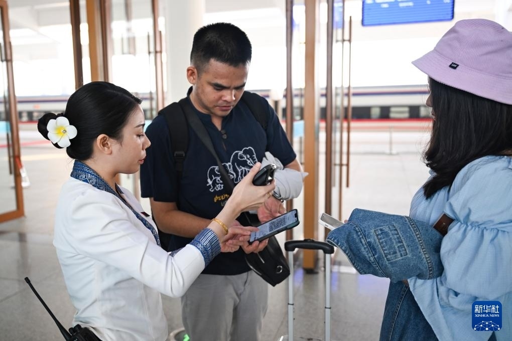 10月12日，在老撾萬(wàn)象中老鐵路萬(wàn)象站，工作人員檢驗(yàn)乘客車票。新華社記者 程一恒 攝