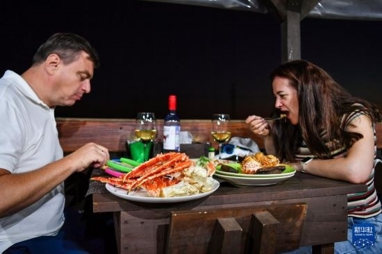 9月2日，食客們?cè)诙砹_斯符拉迪沃斯托克的一家餐館品嘗帝王蟹。新華社記者 曹陽(yáng) 攝
