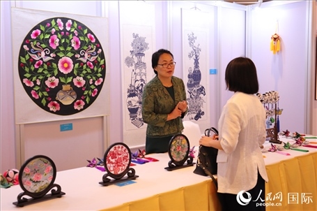 青海非遺文化傳承人向嘉賓介紹展品。人民網(wǎng)實(shí)習(xí)生姚欣可攝