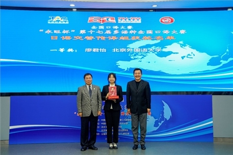 中國翻譯協(xié)會副會長中國外文局中東歐與中南亞傳播中心（人民畫報社）主任姜永鋼（右一）、原中國教育工會全國委員會巡視員白立文（左一）為獲得日語交傳組一等獎的北京外國語大學廖君怡頒獎（主辦方提供）