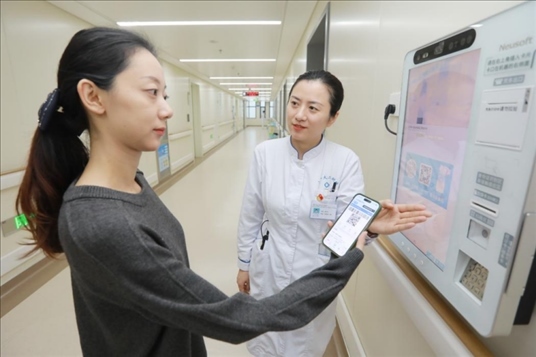 醫(yī)護(hù)人員引導(dǎo)患者在自助機(jī)前辦理自助入院手續(xù)。圖片來(lái)源：山東第一醫(yī)科大學(xué)第二附屬醫(yī)院