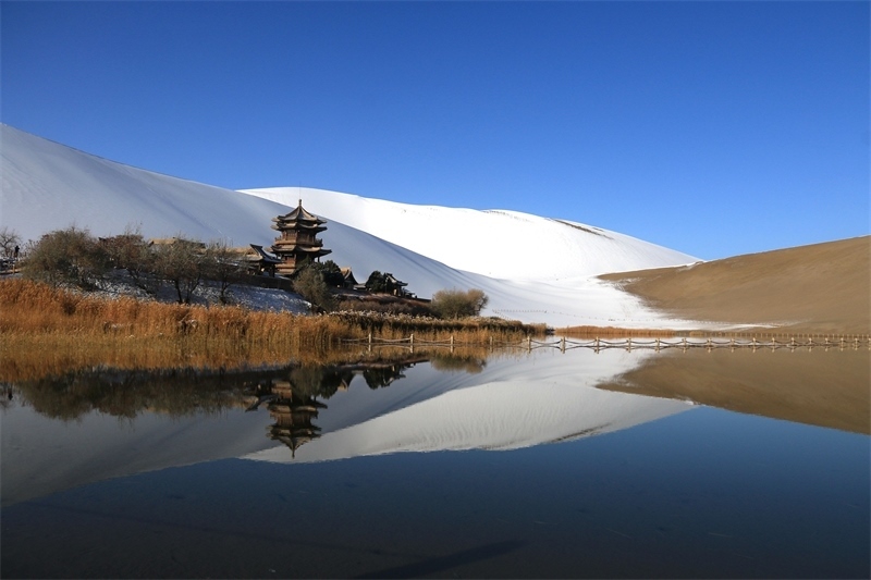 鳴沙山月牙泉景區(qū)雪景。敦煌市委宣傳部供圖，張曉亮攝
