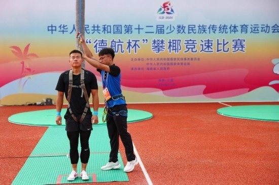 11月23日，工作人員為上海隊(duì)選手付樂樂（左）系安全繩。新華社記者 楊植森 攝