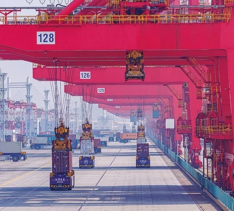 共建“一帶一路”國家在工作制度對(duì)接、技術(shù)標(biāo)準(zhǔn)協(xié)調(diào)、檢驗(yàn)結(jié)果互認(rèn)等方面強(qiáng)化合作、統(tǒng)一標(biāo)準(zhǔn)，貿(mào)易自由化便利化水平不斷提升。上海洋山港海關(guān)對(duì)接共建國家進(jìn)出口貨物相關(guān)標(biāo)準(zhǔn)，推動(dòng)通關(guān)一體化方式申報(bào)，提升通關(guān)效率。圖為無人駕駛的全自動(dòng)導(dǎo)引車在洋山港穿梭往來，搬運(yùn)集裝箱。王初 攝