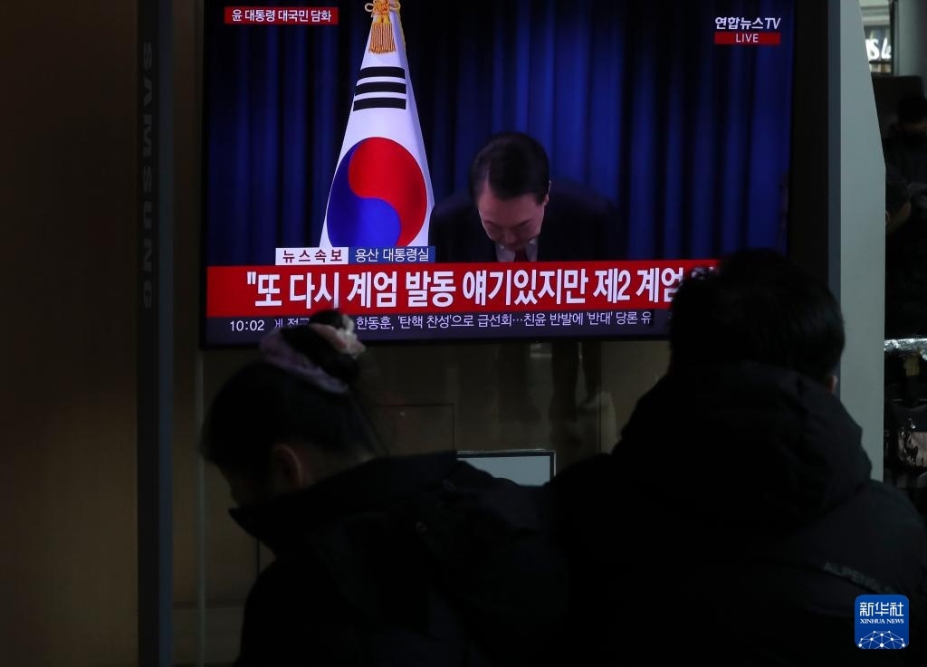 12月7日，在韓國首爾火車站，民眾觀看總統(tǒng)尹錫悅發(fā)表講話的電視畫面。新華社記者 姚琪琳 攝