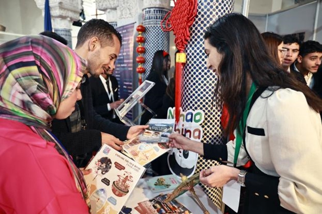 摩洛哥觀眾在中國展臺前觀看宣傳資料。拉巴特中國文化中心供圖