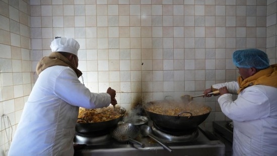 1月14日，服務(wù)隊(duì)的兩名廚師正在為村民們做午飯。新華社記者 邱星翔 攝