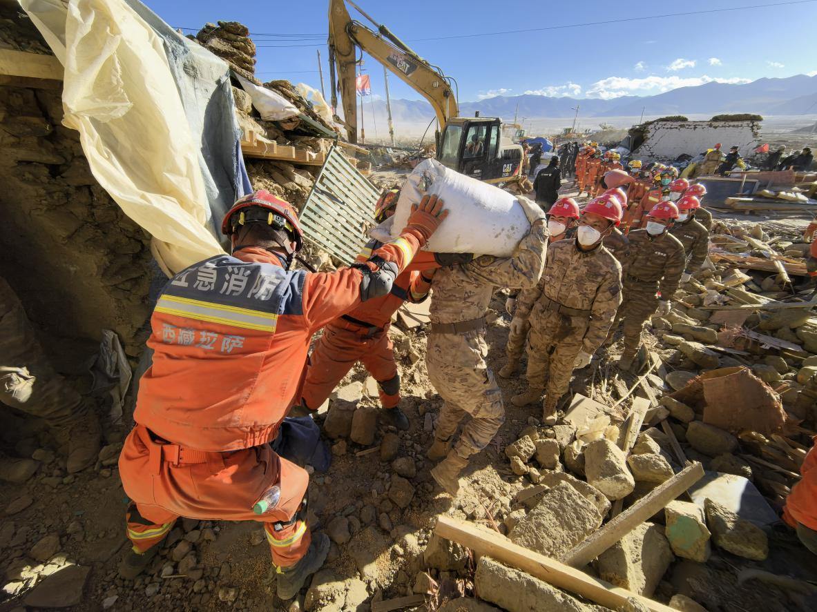 1月11日，定日縣長所鄉(xiāng)古榮村，應(yīng)急消防等救援人員排隊(duì)接力搶運(yùn)掩埋在倒塌房屋下的群眾財(cái)物。人民日?qǐng)?bào)記者楊翹楚攝