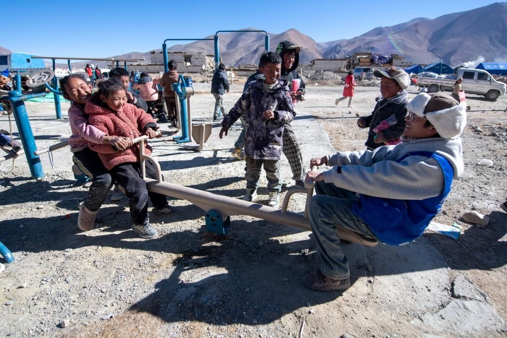 1月11日，在定日縣措果鄉(xiāng)塘仁村安置點(diǎn)，西藏星光社會(huì)工作服務(wù)中心志愿者和孩子們一起玩耍，進(jìn)行災(zāi)后心理疏導(dǎo)。人民網(wǎng)記者 翁奇羽攝