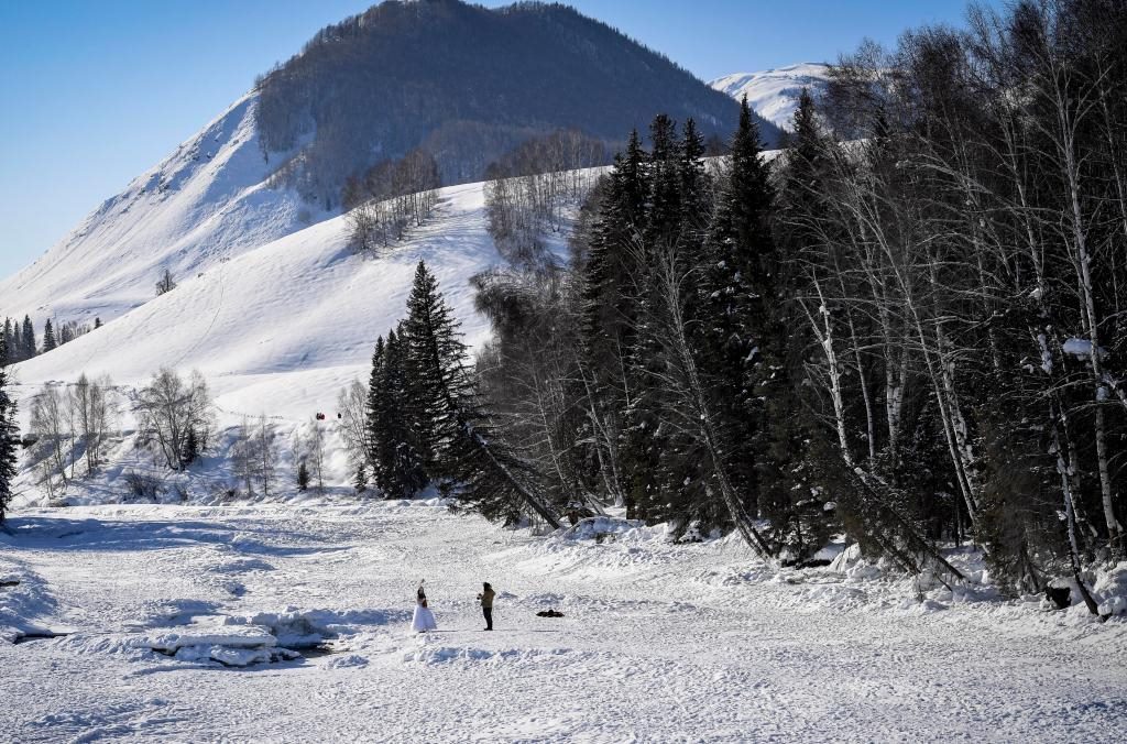 2024年2月5日，兩名游客在新疆阿勒泰地區(qū)布爾津縣禾木村拍照。新華社記者 馬鍇 攝