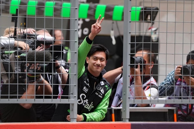 2024年4月19日，索伯車隊中國車手周冠宇（中）在練習(xí)賽前向觀眾致意。當日，F(xiàn)1中國大獎賽在上海開賽。中國車手周冠宇主場首秀參賽。新華社記者 夏一方攝