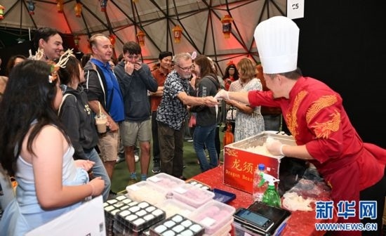圖為游客在燈節(jié)現(xiàn)場購買小吃。（圖片由奧克蘭中國文化中心提供）