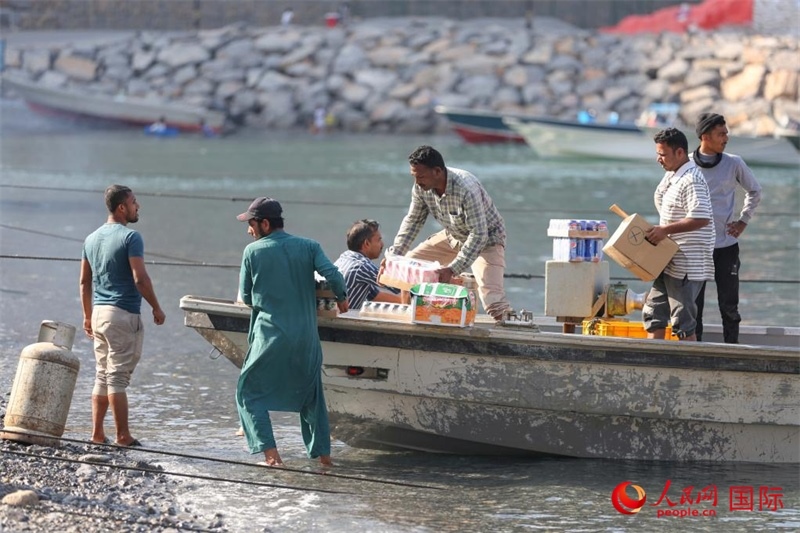 當(dāng)?shù)厝藗冊谶\送生活物資。人民網(wǎng) 塔里克·易卜拉欣攝